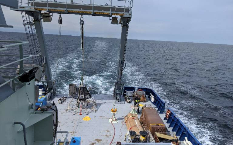 A scientific device sits on the deck of a ship at sea - Multicorer rig on the st