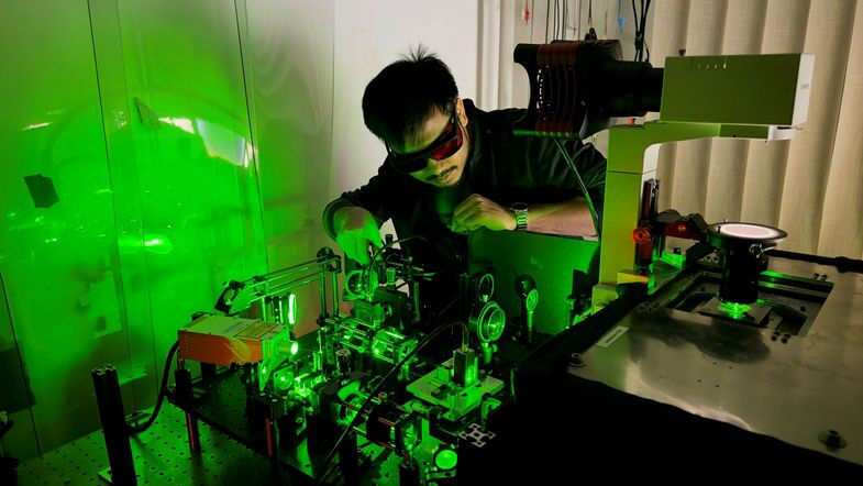 Computer Science - Diptabrata Paul adjusting the experimental setup in which machine learning and microswimmers are coupled in liquid flows, photo: Frank Cichos Computer Science