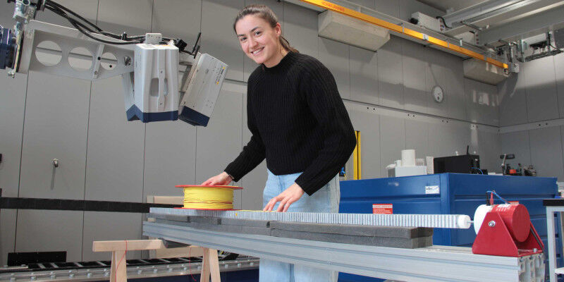 Researcher Simone Probst demonstrates the experimental setup used to test fibre-