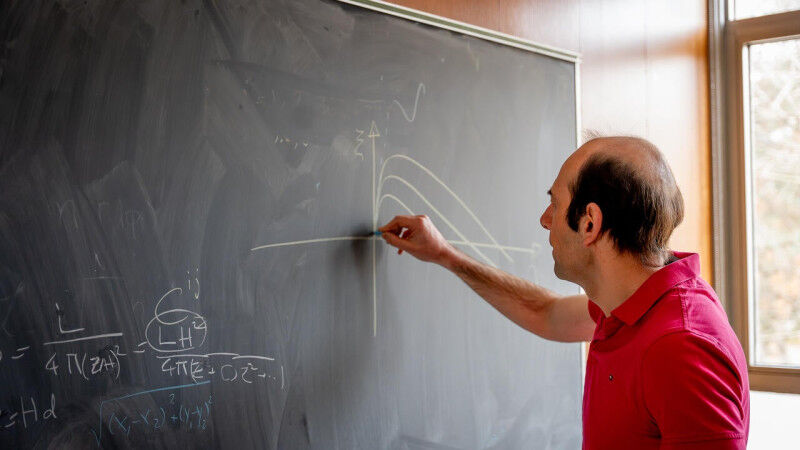 Astronomy & Space - Man uses chalk to draw lines on a blackboard Astronomy & Space