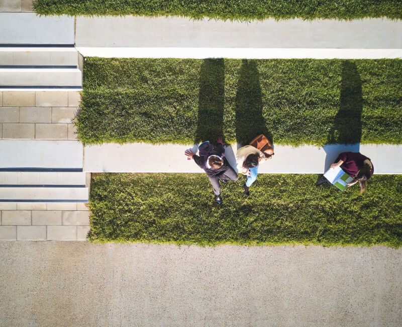 Aerial view of three people studying outside on ANU campus