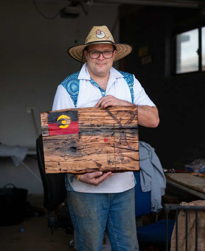 John Gilroy holds his work The Head And Hands Need The Heart