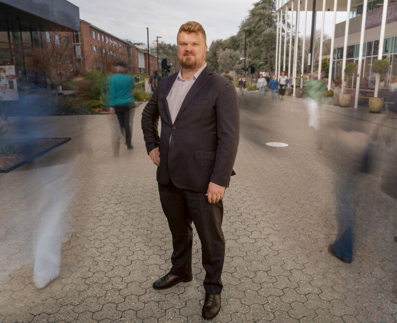 Composite image of Prof Alan Gamlen standing on University Avenue. He is wearing
