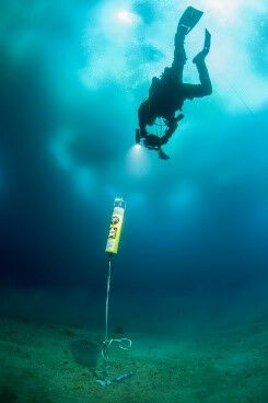 A diver checks and retrieves a hydrophone under the sea ice off Ad�lie Land. � E