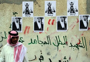A Bahraini man passes images of Abdel Redha Buhameed in the western village of M
