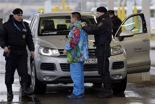 Russian police screen a driver and his vehicle at an entrance to the 2014 Olympi