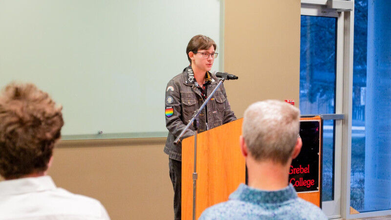 Lucas Shumaker speaking from a podium at Conrad Grebel University College
