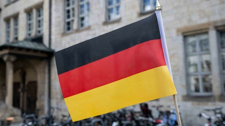 German flag in front of the university main building. Image: Jens Meyer (Univers