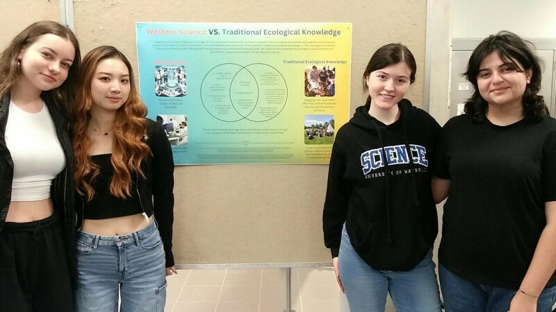 Four students sharing their poster on western science vs. Traditional Ecological