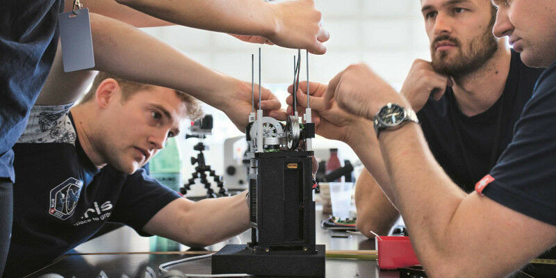 The ARIS SAGE CubeSat team assembles a prototype of the cube-shaped satellite. (