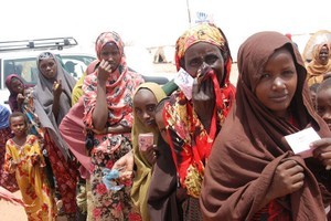 P. Heinlein/Voice of America    Somali refugees hold meal cards outside a feedin