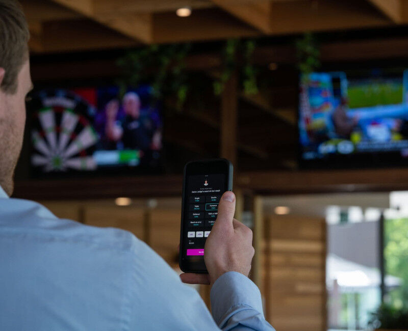 Close-up of man watching sport while phone betting