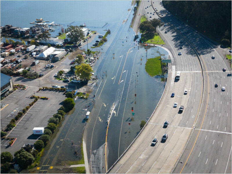 An unusually high tide, called a King Tide, floods a highway on-ramp in Northern