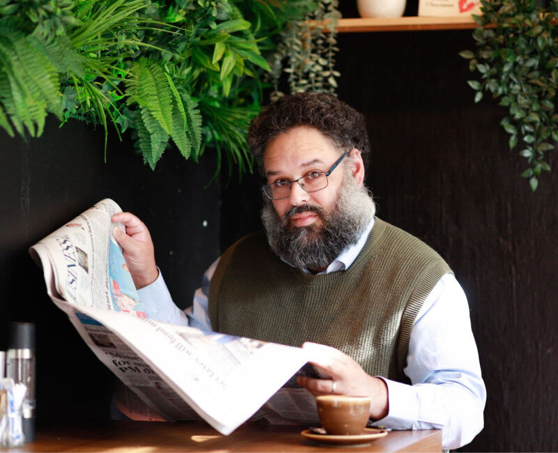 Associate Evan Calford reads newspaper