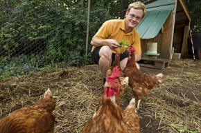 Jackson Carr feeds the chickens in the University's organic garden. Photo b