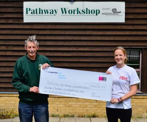 Charlotte le Flufy of RAG hands over a cheque to the Pathway Workshop in Blackbi