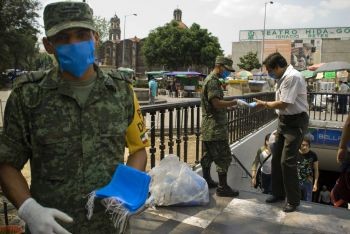 Soldiers hand out masks near a shopping mall in Mexico City after the emergence 