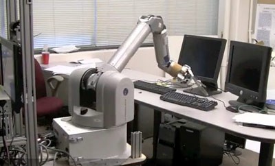 After scanning a room, a robot points to the keyboard it was asked to locate. It