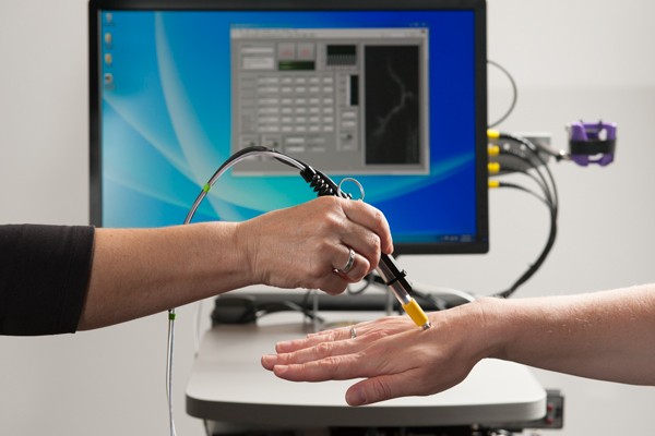 A pen-size microscope focuses a low-power laser light on a blood vessel just bel