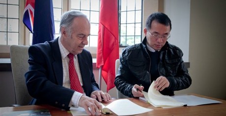John Hearn and Liang Hongsheng sign the agreement between the University and the