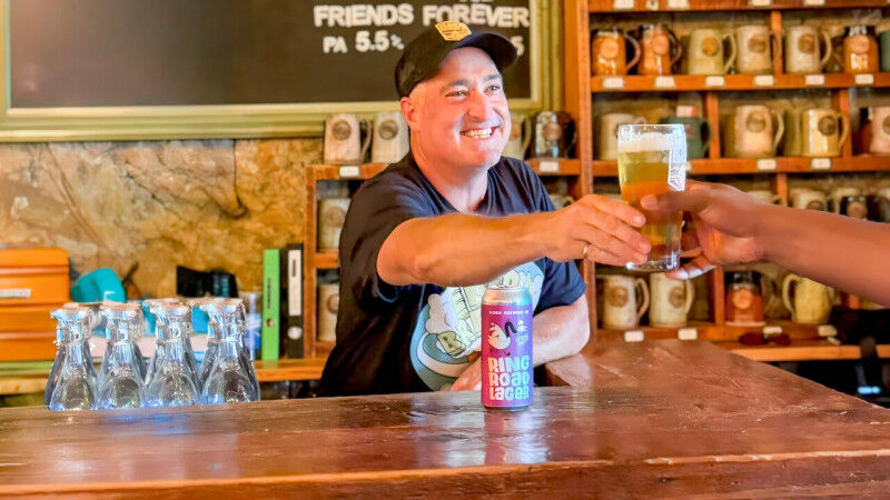 Jim Murphy (BASc ’95) handing a customer a glass of Elora Brewing beer wit