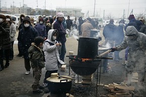 Above: Children line up for food and water at an evacuation center in Sendai. Ph