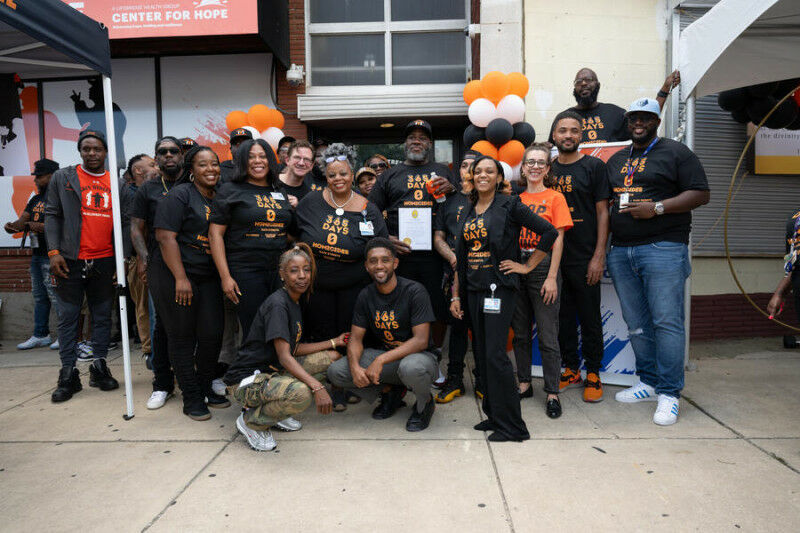 A group photo with Baltimore Mayor Brandon Scott celebrating a year without homi