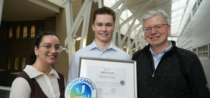 Harshita Gauba, left, Connor Hass, and Marc Poulin hold the FISU platinum certif