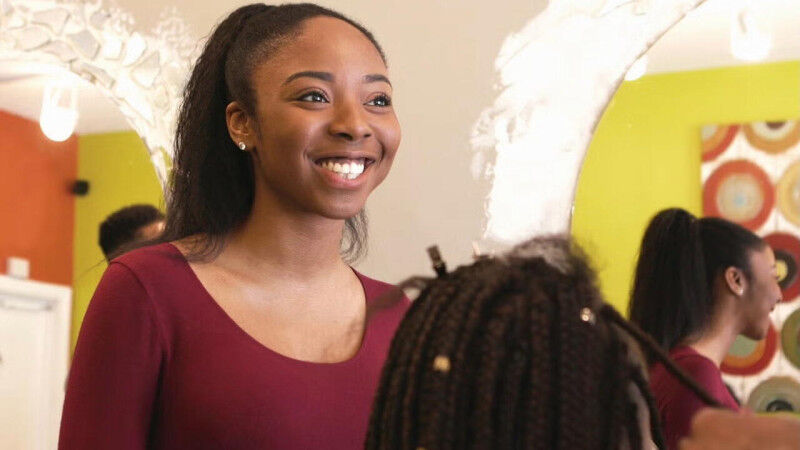 Persons standing and sitting in a hair salon